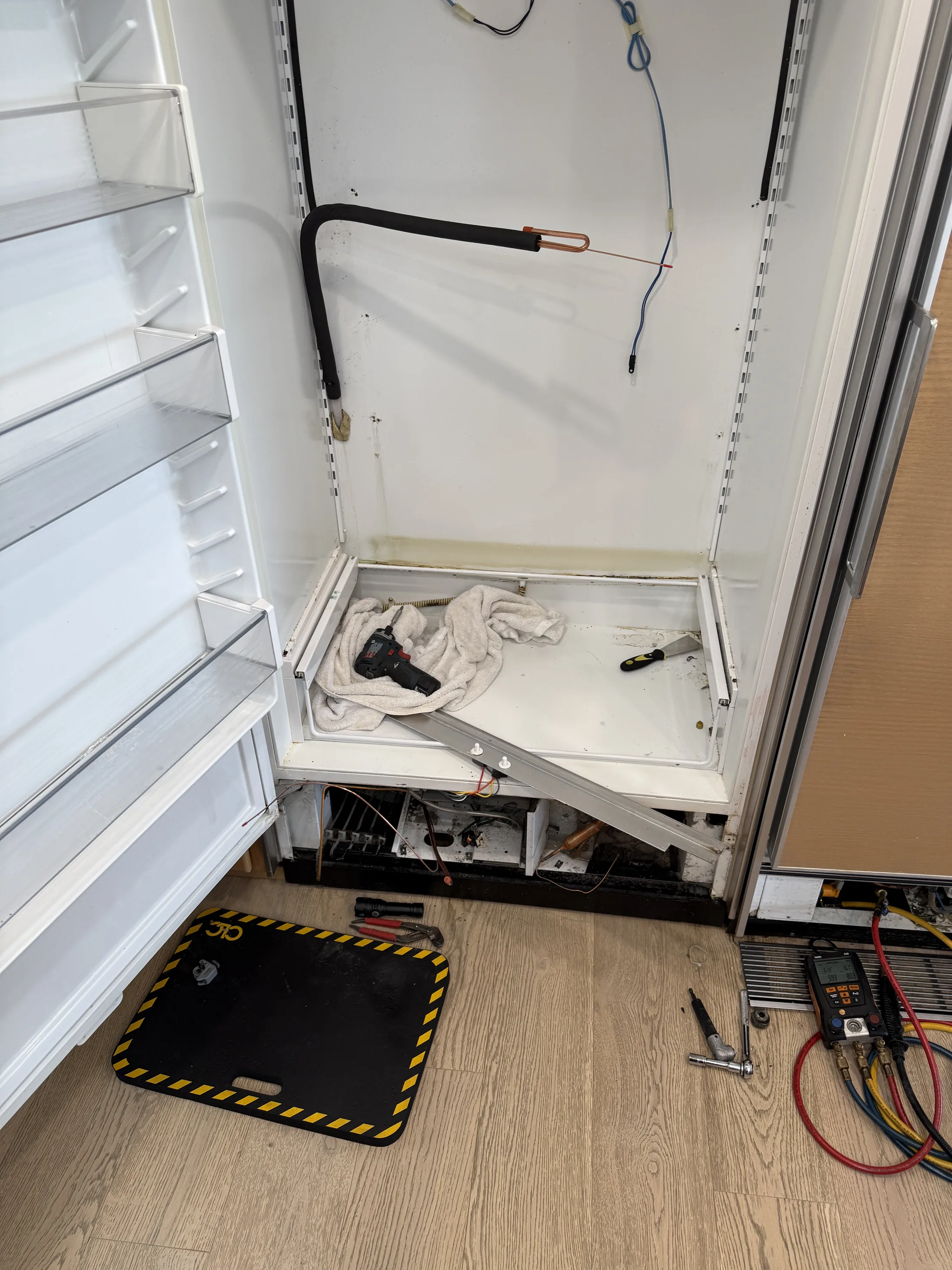 Open Sub-Zero freezer column with wiring exposed during diagnostics